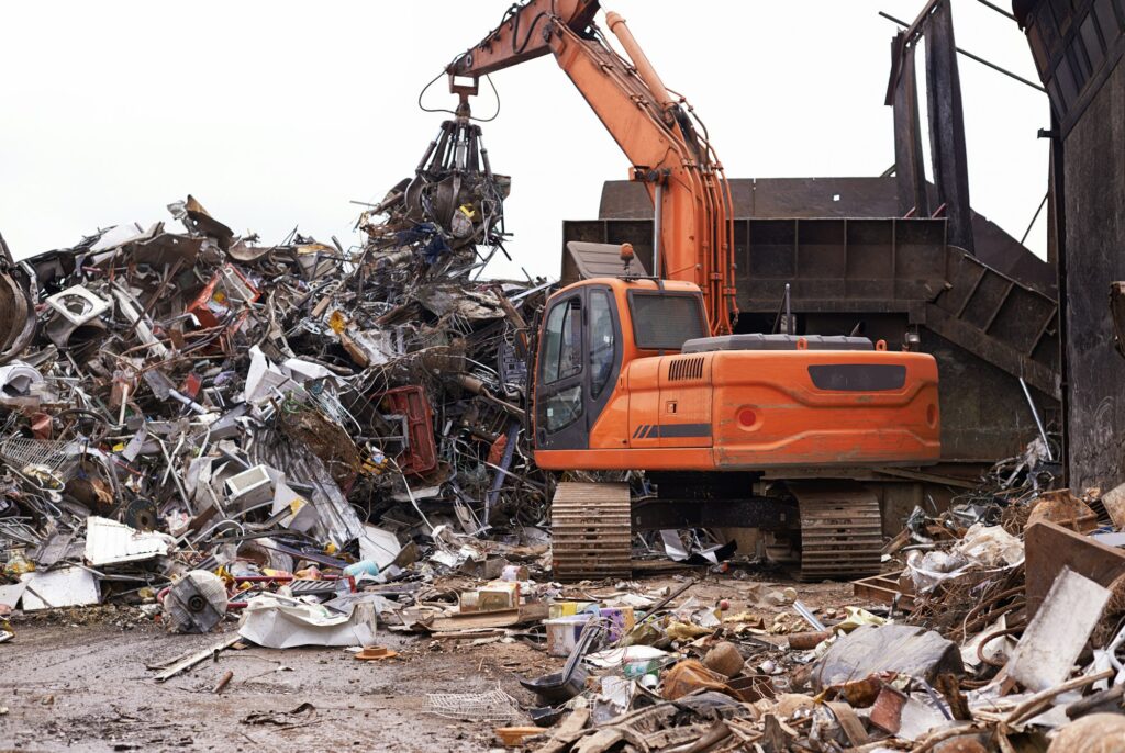 The scrapyard. Cropped shot of an excavator sorting through a pile of scrap metal.